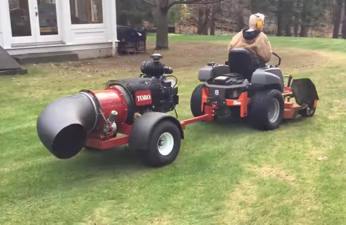 A tow-behind gas leaf vacuum is like a tractor, only it sucks leaf litter instead of cutting grass.